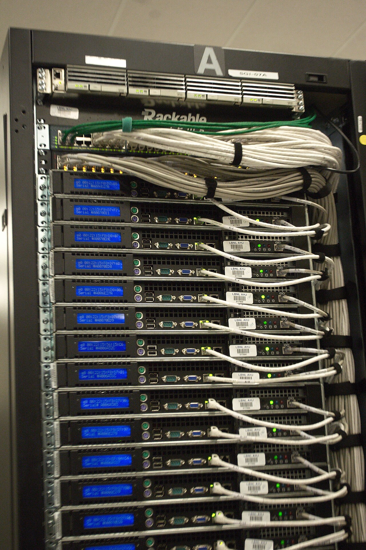 The back of a server rack: cables, blue status screens and serial labels